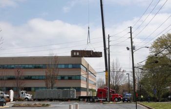 Big crane moving industrial HVAC unit.