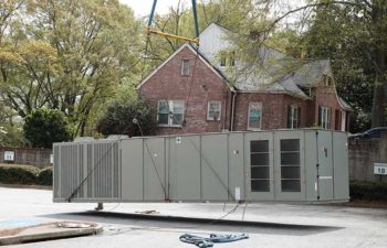 Big crane moving industrial HVAC unit.