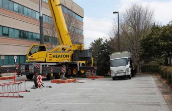 Big crane and JS Thomas truck with industrial HVAC unit.