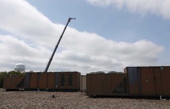 Big crane moving industrial HVAC.