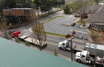 Big crane moving industrial HVAC. Trucks with HVAC units.