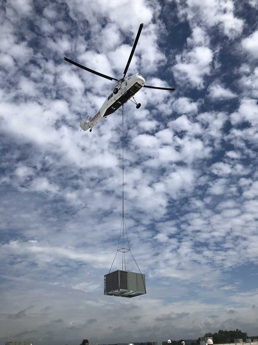 JS Thomas Mechanical helicopter. Air crane transporting HVAC unit.